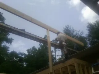 Carpenter setting a ridge beam over a new addition frame — Ice Dam Removal by Roofing Brothers in Lindsay